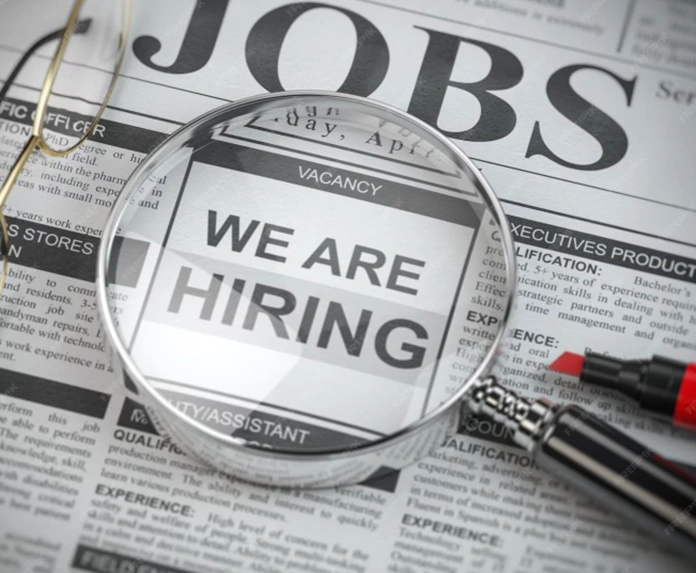 job listings highlighted in a newspaper under a magnifying glass a representation of employment trends